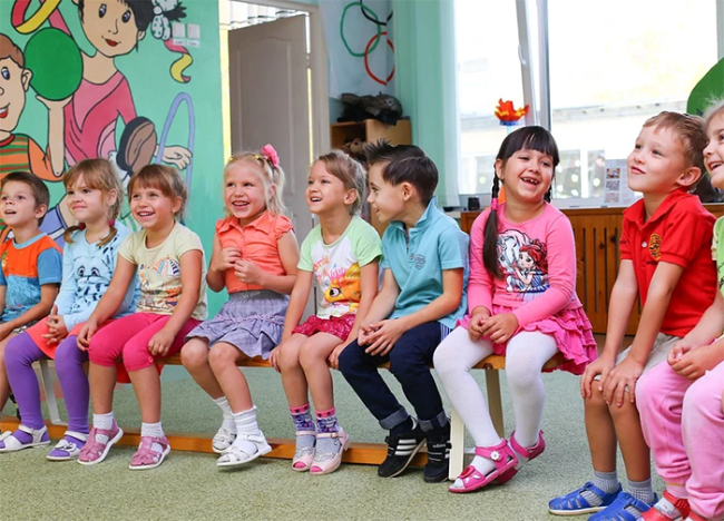 bambini asilo seduti sorrisi